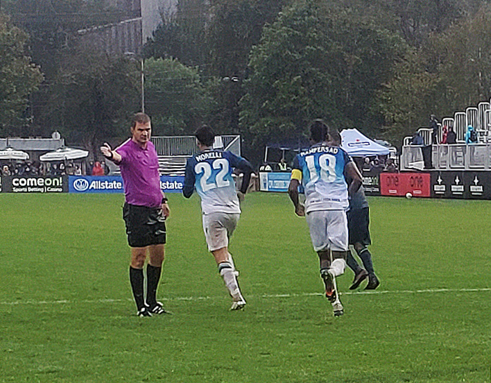 Vista aérea de un partido de fútbol en estadio lleno durante la noche